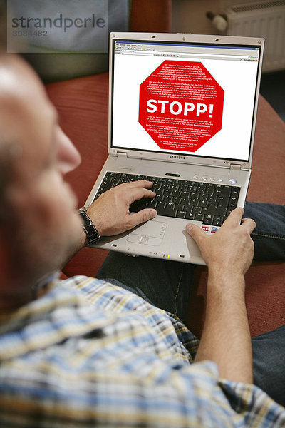 Mann sitzt am Computer  surft im Internet  Stopp-Schild  geblockte Internetseite