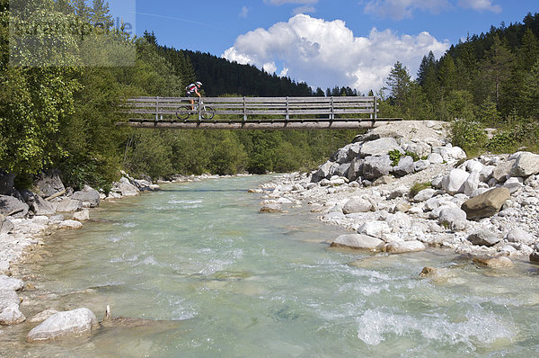 Mountainbike-Fahrerin auf kleiner Holz-Brücke über die Leutascher Ache im Gaistal  Leutasch  Tirol  Österreich