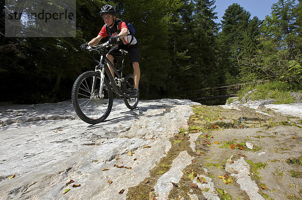 Mountainbike-Fahrer auf Felsplatten im Eschenlainetal  Eschenlohe  Oberbayern  Bayern  Deutschland