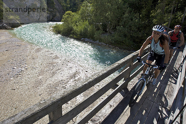 Mountainbike-Fahrerin und -Fahrer auf Holz-Brücke über die Isar am Wiesenhof bei Scharnitz  Tirol  Österreich