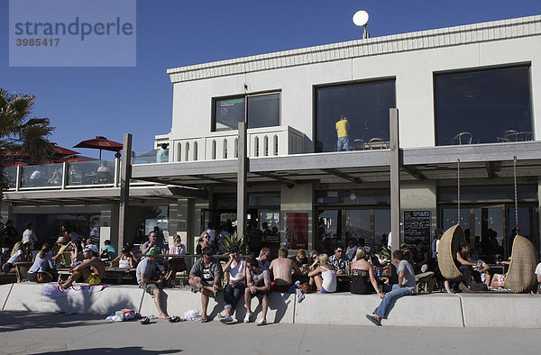 Menschen sitzen im und vor einem Strandcafe in St. Kilda  einem Vorort von Melbourne  Victoria  Australien