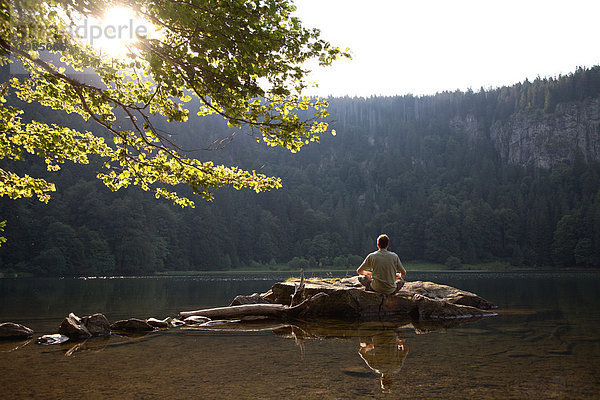 Mann  Mitte 40  meditiert am Feldsee im Schwarzwald  Baden-Württemberg  Deutschland  Europa