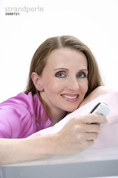 Frau in pinker Bluse mit Handy