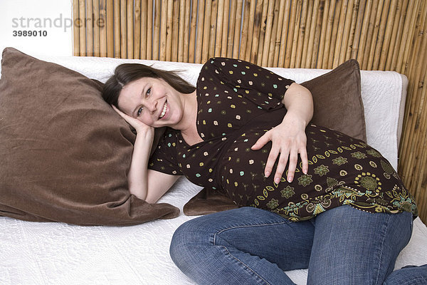 Schwangere Frau gemütlich auf dem Sofa