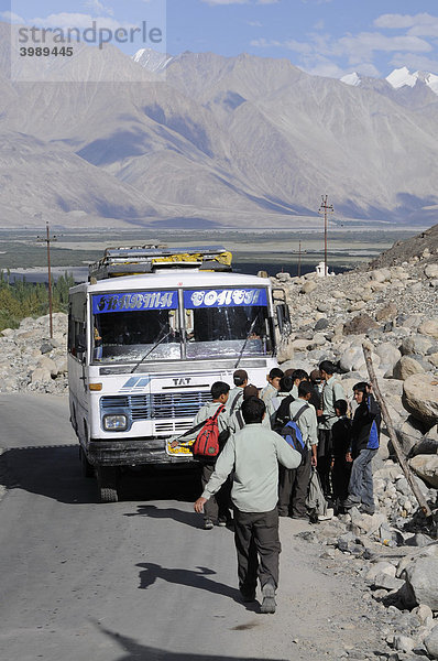 Schüler in Uniform steigen in den Schulbus in Hundar  Nubratal  Indien  Himalaja