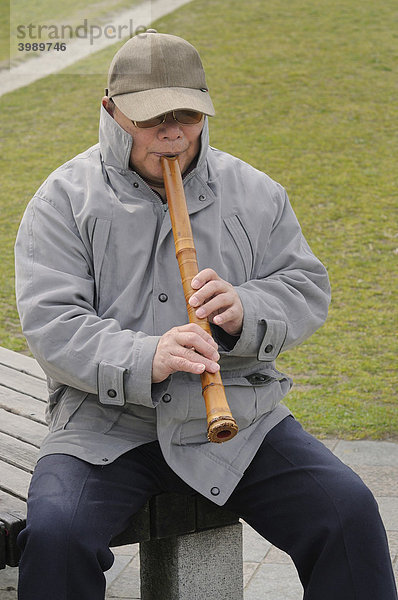 Japaner spielt in der Natur die Shakuhachi  traditionelle Bambusflöte  am Kamu Fluss  Kyoto  Japan  Asien