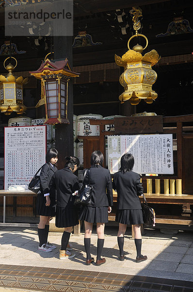Schüler in Uniform beten vor einem Shinto-Schrein  Kintano Schrein  Kyoto  Japan  Ostasien  Asien