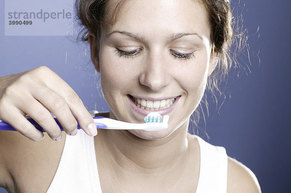 Junge Frau mit Zahnbürste und Zahnpasta