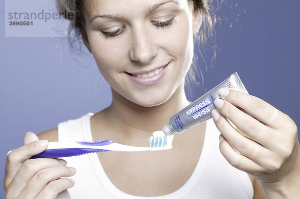 Junge Frau mit Zahnbürste und Zahnpasta  Whitening-Mittel