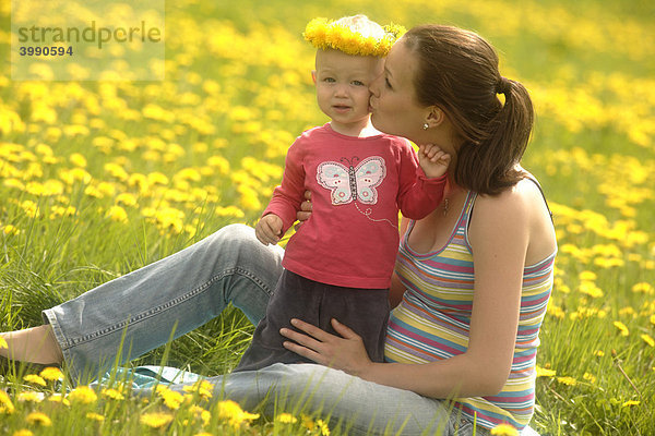 Schwangere Mutter mit Baby  Mädchen  in der Frühlingwiese