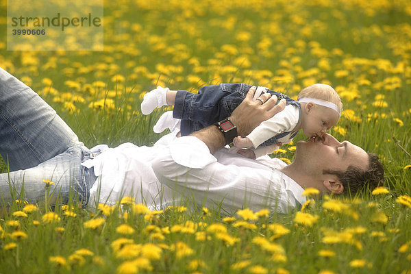 Vater mit Baby  Mädchen  in der Frühlingwiese