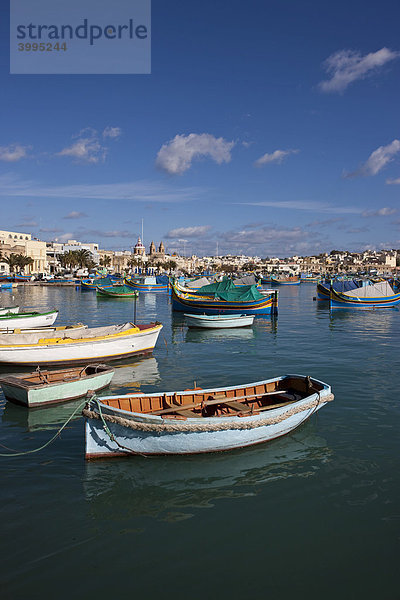 Traditionelle maltesisches Fischerboote im Hafen von Marsaxlokk  hinten die Kirche Lady of Pompei  Malta  Europa