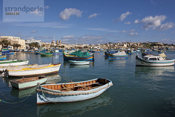 Traditionelle maltesisches Fischerboote im Hafen von Marsaxlokk  hinten die Kirche Lady of Pompei  Malta  Europa