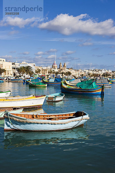 Traditionelle maltesische Fischerboote im Hafen von Marsaxlokk  hinten die Kirche Lady of Pompei  Malta  Europa