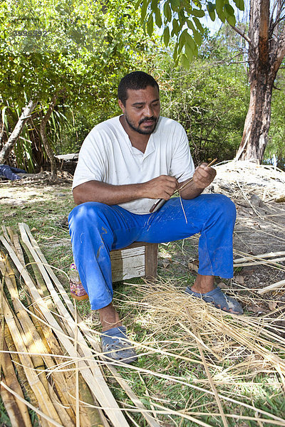 Ein Mann fertigt aus Bambus eine Fischreuse  Insel Mahe  Seychellen  Indischer Ozean  Afrika