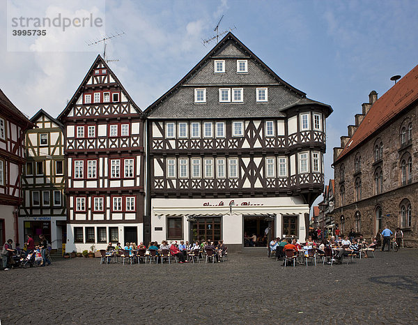 Touristen sitzen in der Sonne vor einem Kaffee auf dem Marktplatz  Altstadt  Alsfeld  Hessen  Deutschland  Europa