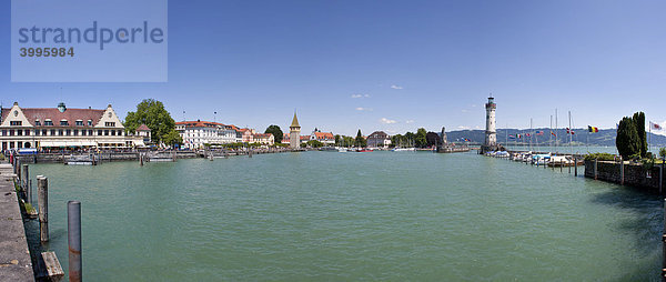 Blick auf Lindau und den Hafen von Lindau mit dem Leuchturm  hinten das Denkmal des über den See schauenden Löwen des Bildhauers Johann von Halbig  Lindau am Bodensee  Bayern  Deutschland  Europa