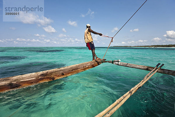 Eine arabische Dau  Dhau  fährt in einer blauen Lagune  Sansibar  Tansania  Afrika