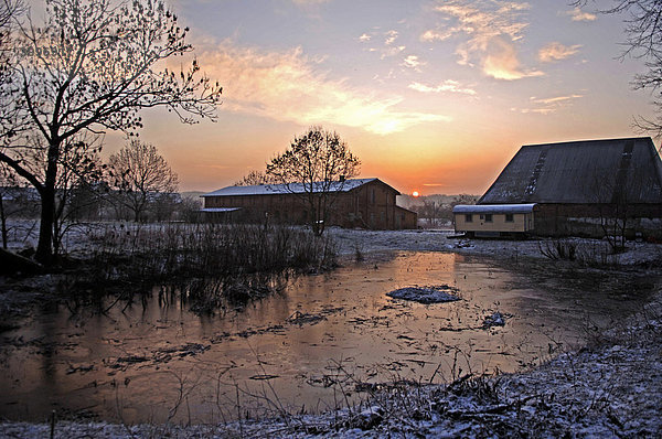 Sonnenaufgang auf einem alten Gehöft  vorne zugefrorener Weiher  Othenstorf  Mecklenburg-Vorpommern  Deutschland  Europa