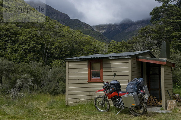 Schwer bepacktes Enduro Motorrad vor einer Wanderhütte in der Nähe des Mount Cashel  Südinsel  Neuseeland