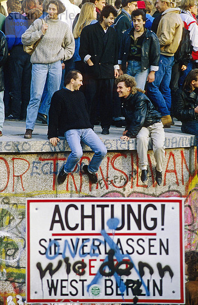 Zwei Männer auf der Berliner Mauer am Brandenburger Tor  am Tag nach dem Mauerfall  Berlin  Deutschland  Europa