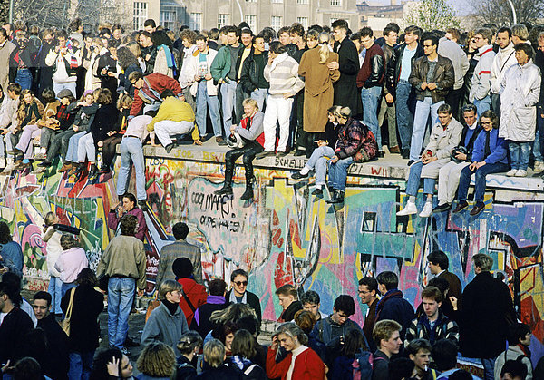 Menschen auf der Mauer am Brandenburger Tor  am Tag nach dem Mauerfall  Berlin  Deutschland  Europa