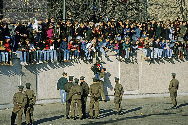 Grenzsoldaten und Menschen auf der Berliner Mauer am Brandenburger Tor  am Tag nach dem Mauerfall  Berlin Mitte  Deutschland  Europa