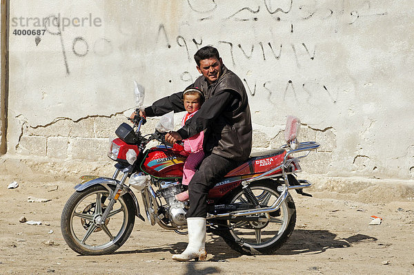 Mann mit Kind auf Motorrad bei Aleppo  Syrien  Asien