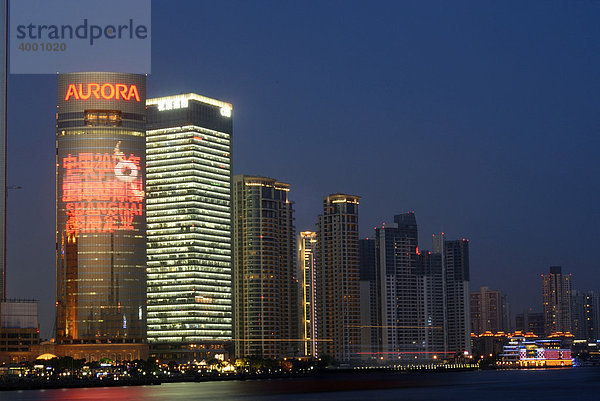 Erleuchtete Skyline mit chinesischer Leuchtreklame des Finanzdistrikts Pudong in Shanghai mit Fluss Huangpu  Shanghai  China