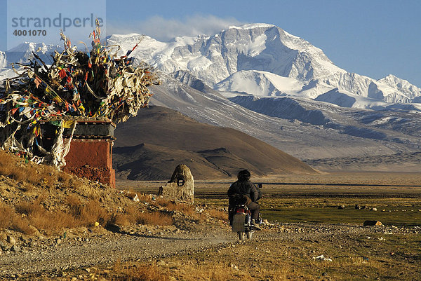 Motorrad mit zwei Männern vor tibetischem Chörten mit Gebetsfahnen vor verschneitem Gebirgszug des Cho Oyo  8112 m  in der Hochebene von Tingri  Tibet  China  Asien