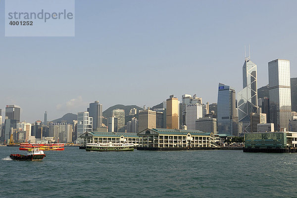 Fährschiff der Star Ferry und Schlepper vor der Skyline und Pier von Hongkong Central  Hongkong  China  Asien