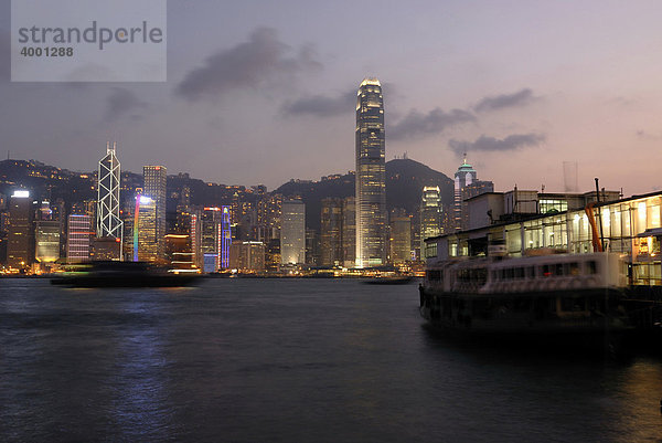 Star Ferry am beleuchteten Pier der Star Ferry Kowloon mit Blick auf die abendlich erleuchtete Skyline von Hongkong Central  Finanzdistrikt  Hongkong  China  Asien