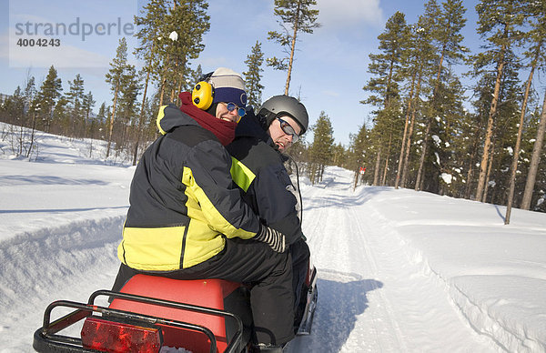 Ein Mann und eine Frau in den Vierzigern auf einer Schneemobil-Tour in Kiruna  Lappland  Nord-Schweden  Schweden