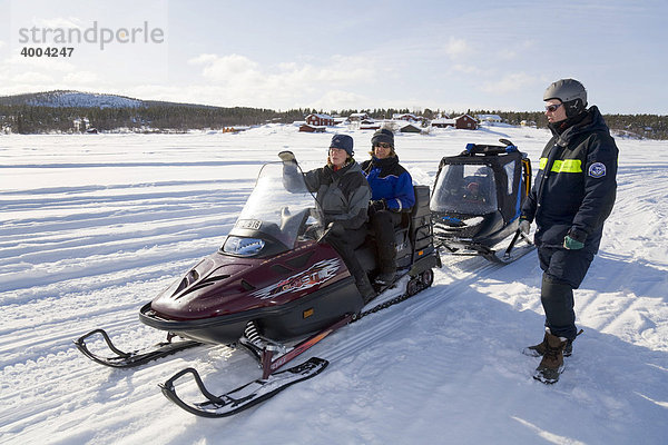 Zwei Frauen und ein Mann in den Vierzigern auf einer Schneemobil-Tour in Kiruna  Lappland  Nord-Schweden  Schweden