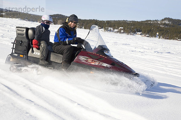 Eine Frau in den Vierzigern und ein sechsjähriges Mädchen auf einer Schneemobil-Tour in Kiruna  Lappland  Nord-Schweden  Schweden