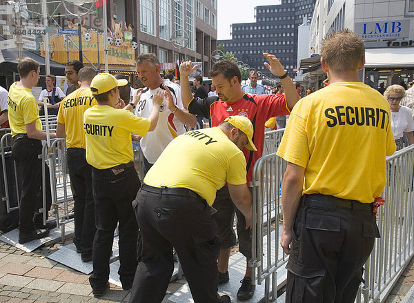 Während der Fußball-Weltmeisterschaft 2006 kontrollieren Sicherheitskräfte Fußballfans am Eingang zum Friedensplatz  wo die Spiele auf einer großen Leinwand übertragen werden  in Dortmund  Nordrhein-Westfalen  Deutschland