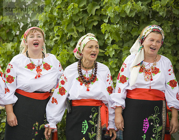 Drei Landfrauen in traditioneller ukrainischer Tracht singen bei einem bäuerlichen Volkstanz im Bauernmuseum in dem ehemaligen von Deutschen bewohnten bessarabischen Dorf Friedenstal  im heutigen Mirnopolje  Ukraine