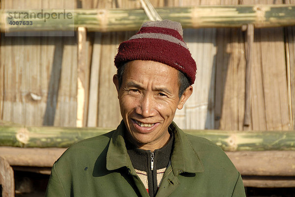 Portrait  lächelnder Laote  Mann der Akha Pixor Ethnie trägt Mütze  Ban Moxoxang bei Boun Neua  Phongsali Provinz  Laos  Südostasien  Asien