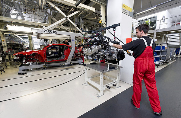 Ein Audi-Mitarbeiter ist in der Audi-R8-Manufaktur mit der Vorbereitung des Einsetzens des Antriebsaggregats in den Sportwagens Audi R8 beschäftigt  Baden-Württemberg  Deutschland  Europa