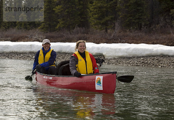 Kanufahrer auf dem Takhini Fluss  dahinter das verschneite Ufer  Yukon Territory  Kanada  Nordamerika