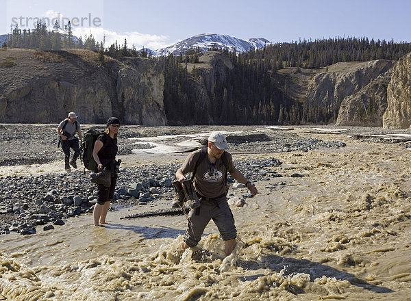 Wanderer überqueren den Sheep Creek Fluss  Slims River Valley  Kluane Nationalpark  St. Elias Range  Eliaskette  Yukon  Kanada