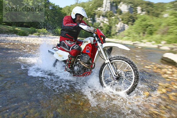 Offroad-Motorradfahrer bei Flussdurchquerung in Südfrankreich  Frankreich  Europa