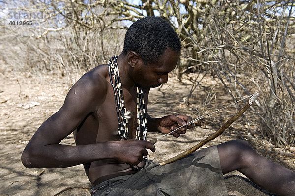 Ein Angehöriger der Hadzabe fertigt einen Jagdpfeil  Lake Eyasi  Tansania  Afrika