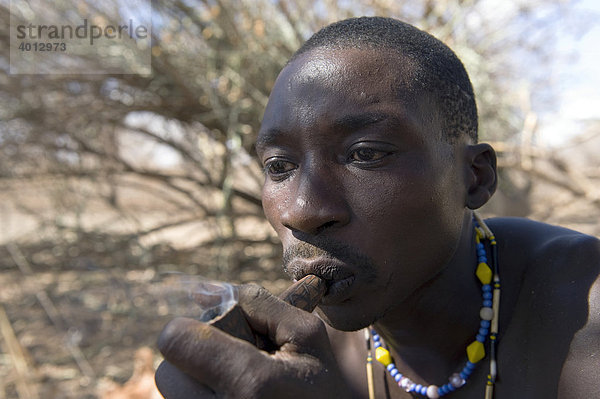 Ein Angehöriger der Hadzabe raucht eine Pfeife mit Marihuana  Lake Eyasi  Tansania  Afrika