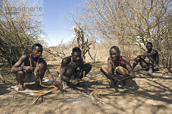 Männer des Hadzabe Stamms fertigen sich Jagdpfeile  Lake Eyasi  Tansania  Afrika