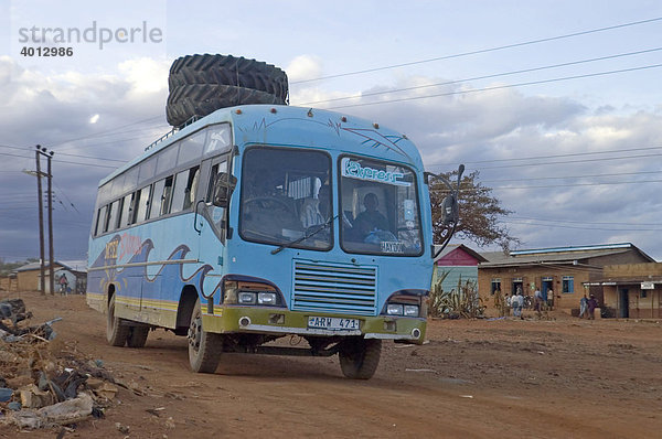 Zwei Treckerreifen wurden zum Transport unkonventionell auf das Dach eines Reisebusses gebunden in Haidom  Tansania  Afrika