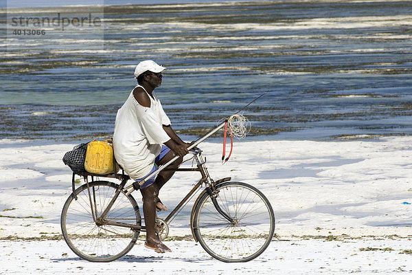 Fischer mit Harpune auf einem Fahrrad am Strand von Bwe Juu  Sansibar  Tansania  Afrika