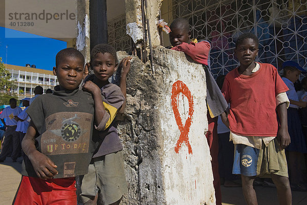 Straßenkinder und Rote Schleife  Red Ribbon  das weltweite Symbol der Solidarität mit HIV-Infizierten und AIDS-Kranken  Quelimane  Mosambik  Afrika