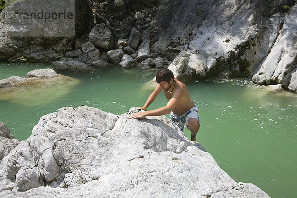 Schwimmer klettert auf Felsen in der Brandenberger Ache  Nordtirol  Österreich  Europa