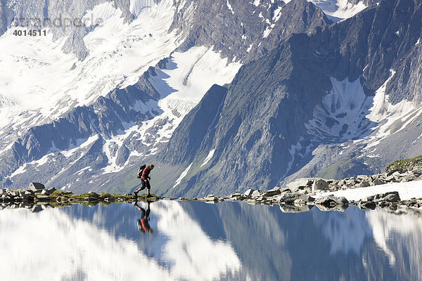 Wanderer spiegelt sich im Friesenbergsee  Zillertaler Alpen  Zillertaler Alpen  Tirol  Österreich  Europa